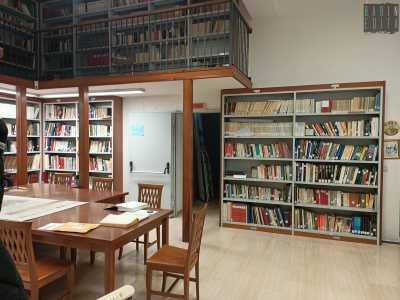 Entriamo e siamo accolti da una sala lettura le cui pareti sono scandite da scaffali colmi di volumi